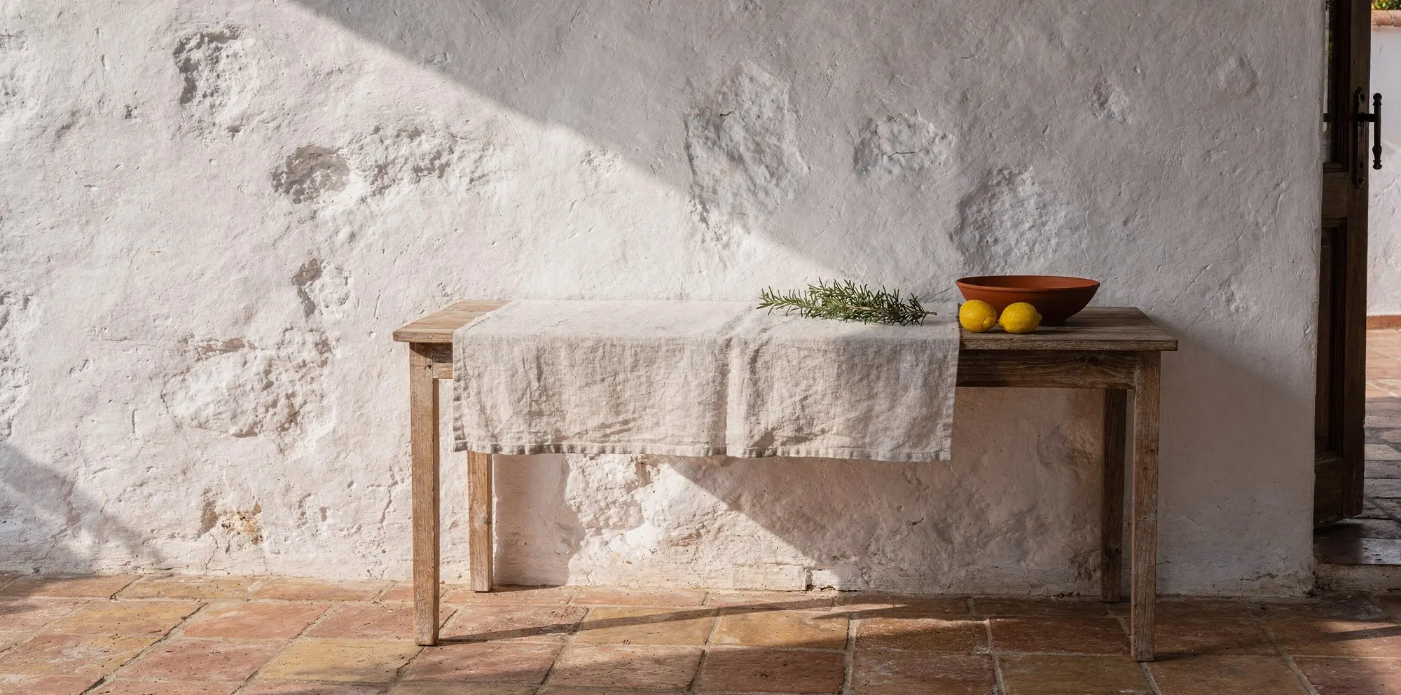 Andalusian courtyard with a teak console, lemons and rosemary